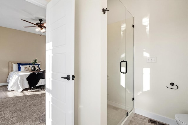 bathroom featuring toilet, walk in shower, and ceiling fan