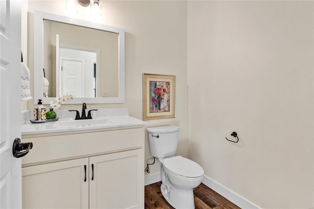 bathroom featuring vanity, wood-type flooring, and toilet