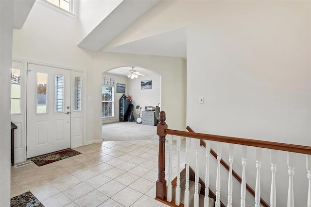 entrance foyer with ceiling fan and light colored carpet