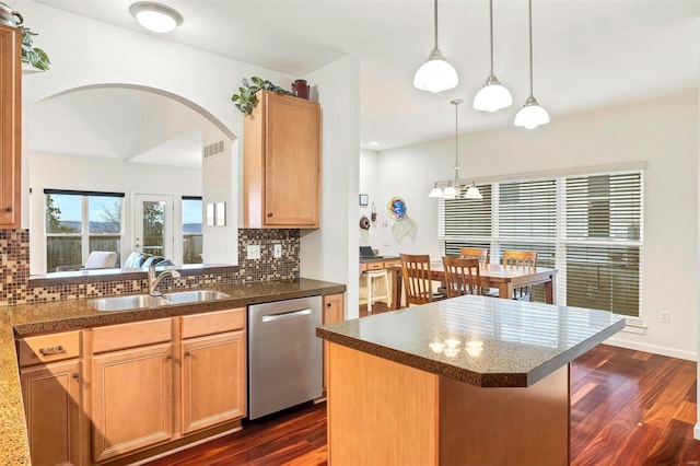 kitchen featuring sink, a center island, tasteful backsplash, stainless steel dishwasher, and dark hardwood / wood-style floors