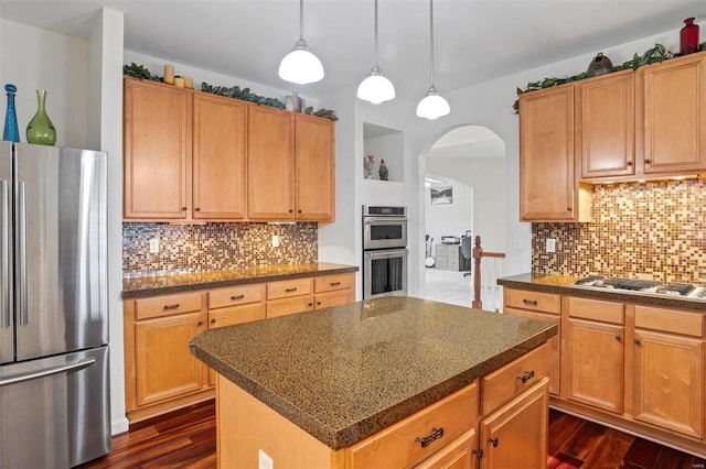 kitchen featuring a kitchen island, backsplash, appliances with stainless steel finishes, and dark wood-type flooring