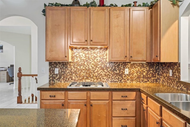 kitchen with tile patterned floors, white gas cooktop, sink, and tasteful backsplash