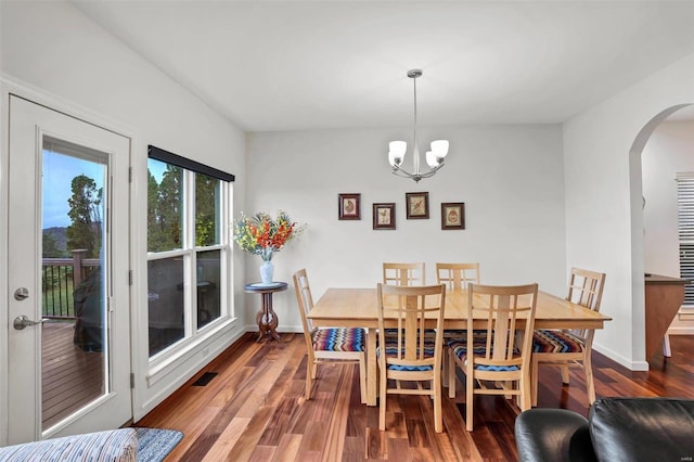 dining room with dark hardwood / wood-style flooring and a chandelier