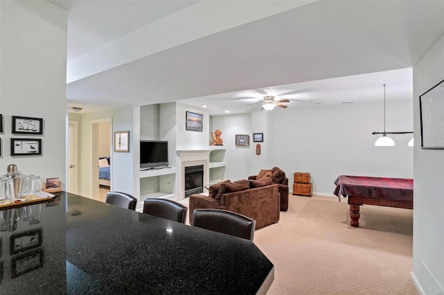 carpeted living room featuring ceiling fan, built in features, and billiards