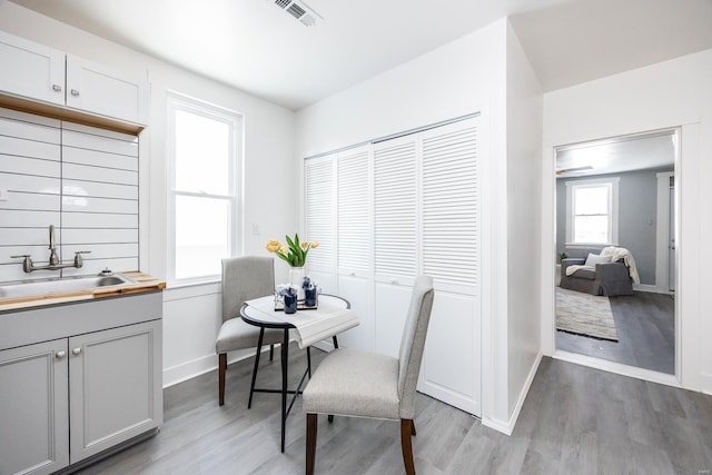 dining area with light hardwood / wood-style floors and sink