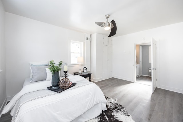 bedroom featuring connected bathroom, ceiling fan, and dark hardwood / wood-style flooring