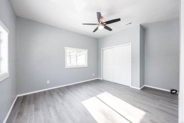 unfurnished bedroom featuring hardwood / wood-style flooring, ceiling fan, and a closet