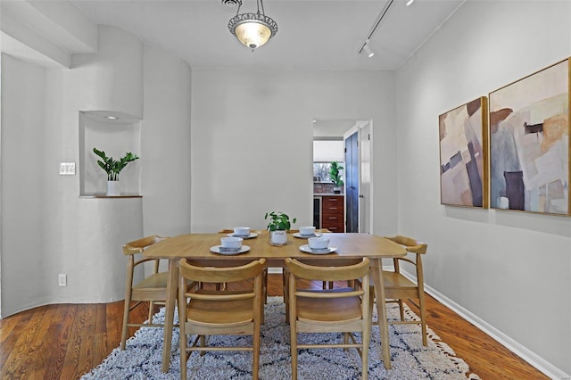 dining room featuring hardwood / wood-style flooring and rail lighting