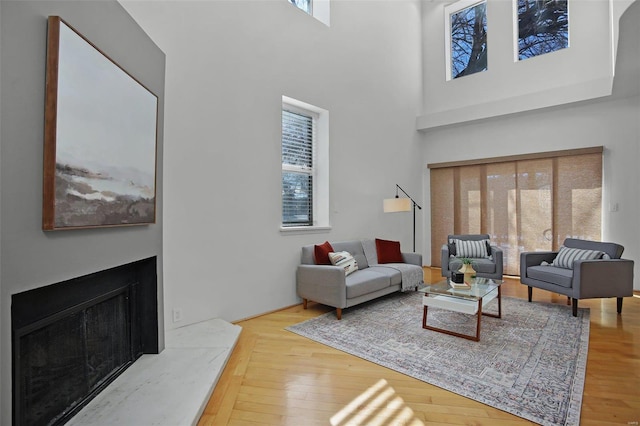 living room with a towering ceiling and hardwood / wood-style floors