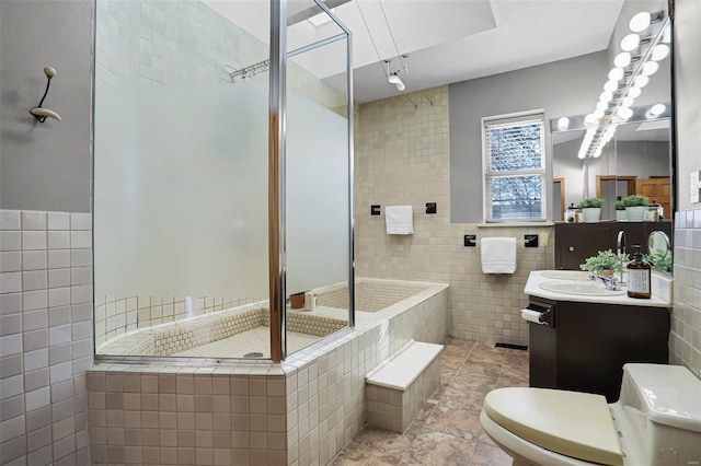 bathroom with tile walls, vanity, toilet, and walk in shower