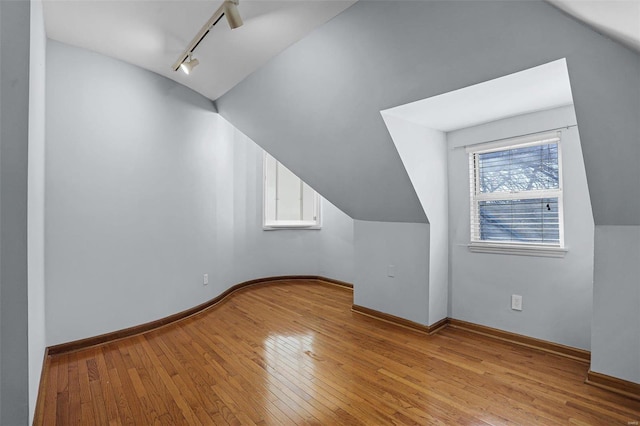 bonus room with vaulted ceiling and light wood-type flooring