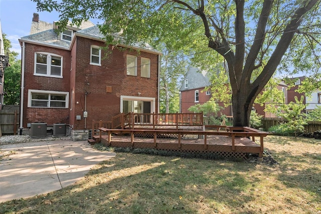 back of property featuring a patio area, a lawn, central AC, and a deck