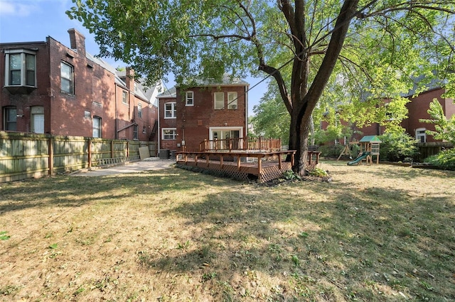 view of yard featuring a wooden deck and a playground