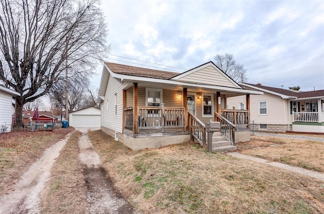 bungalow-style home featuring covered porch, a garage, and an outdoor structure