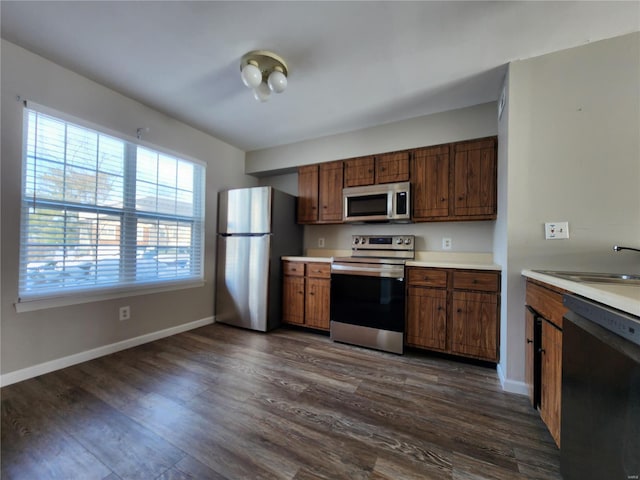 kitchen featuring stainless steel appliances, dark wood-type flooring, and sink