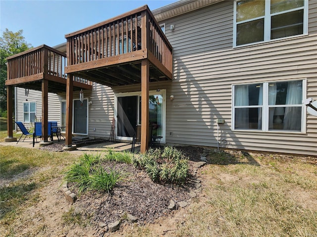 rear view of property featuring a patio area and a wooden deck