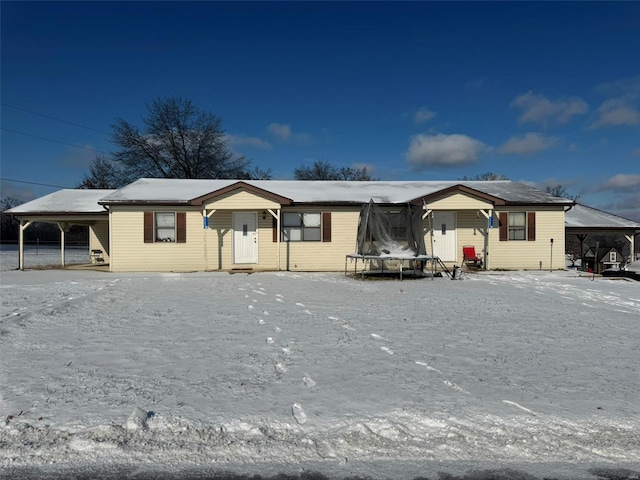 ranch-style home with a trampoline and a carport