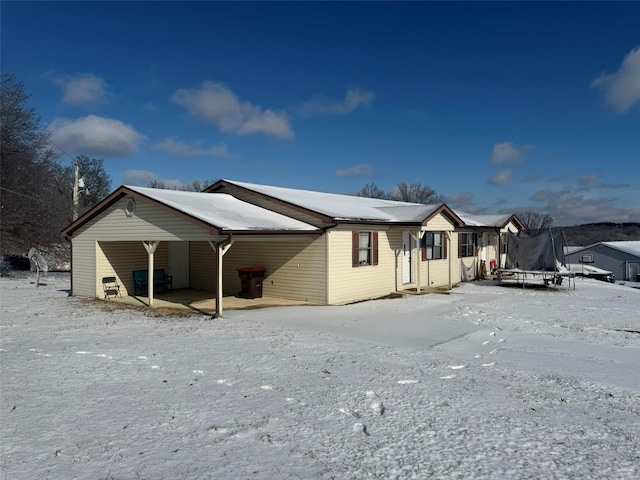 snow covered property with a trampoline