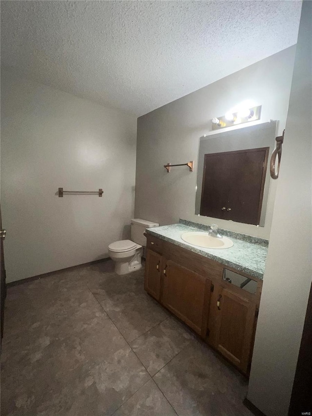 bathroom featuring vanity, a textured ceiling, and toilet