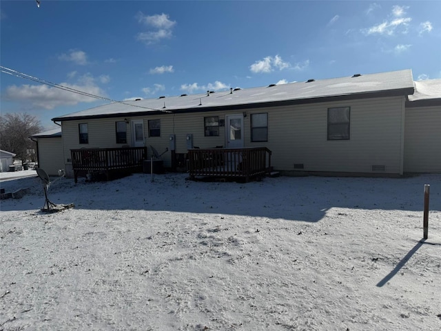 snow covered rear of property featuring a deck