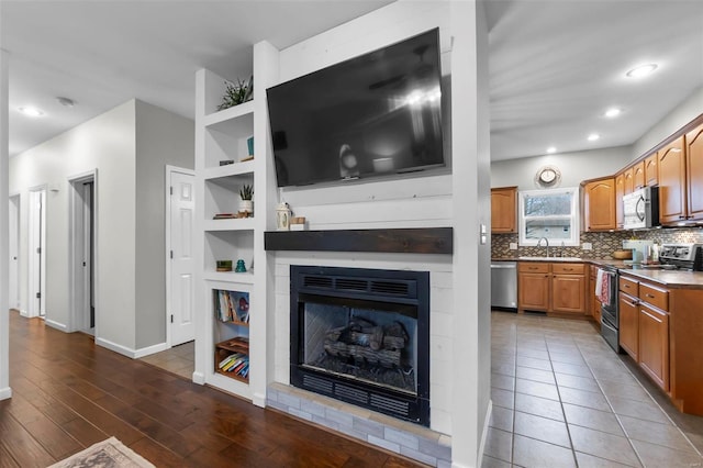 living room with built in shelves, dark hardwood / wood-style flooring, and sink