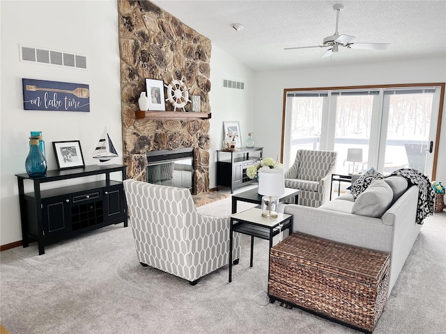 living room with a textured ceiling, a fireplace, lofted ceiling, light carpet, and ceiling fan