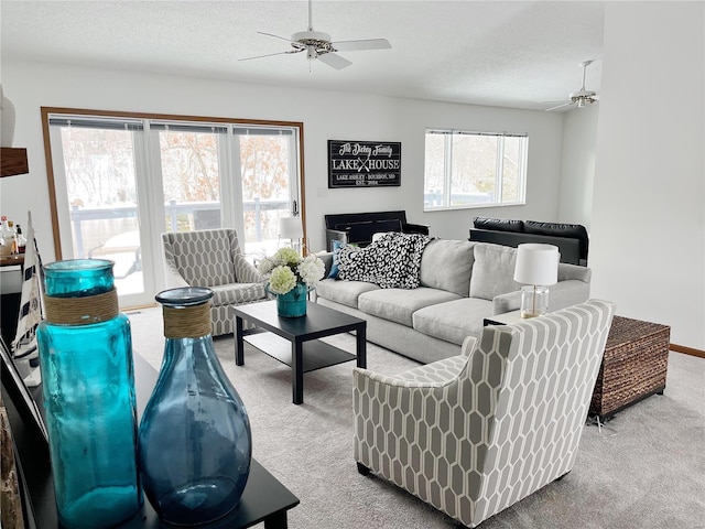 carpeted living room with a textured ceiling and ceiling fan