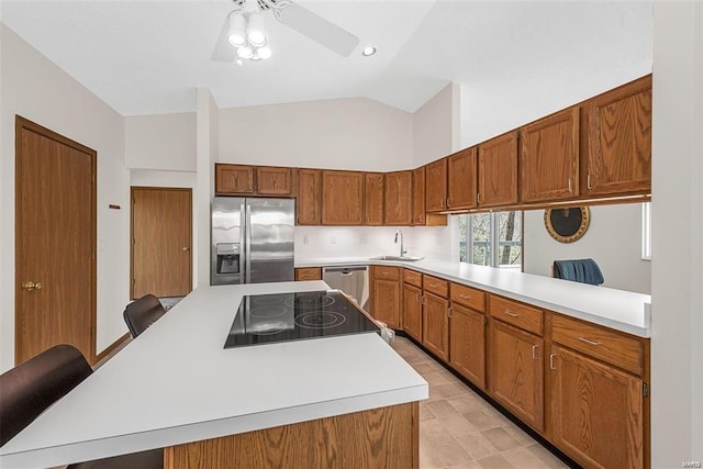 kitchen featuring a kitchen breakfast bar, appliances with stainless steel finishes, kitchen peninsula, ceiling fan, and sink