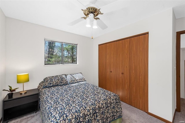 carpeted bedroom featuring ceiling fan and a closet