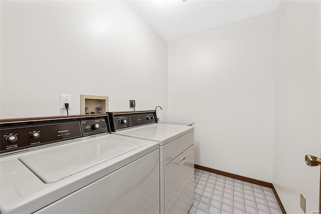 washroom featuring a textured ceiling, separate washer and dryer, and sink