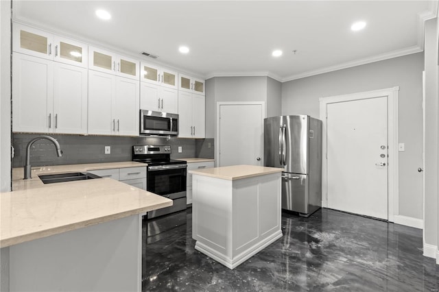 kitchen featuring white cabinets, appliances with stainless steel finishes, a kitchen island, and sink