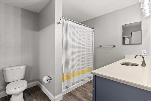 bathroom featuring wood-type flooring, vanity, toilet, and walk in shower