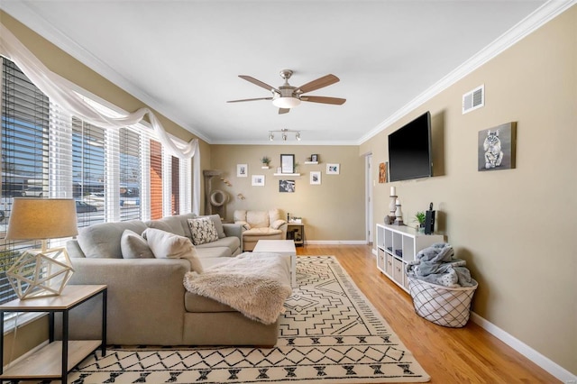 living room featuring hardwood / wood-style floors, ceiling fan, and crown molding