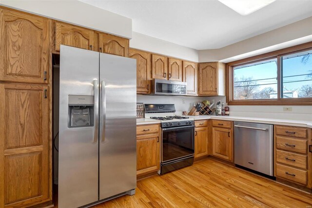 kitchen with stainless steel appliances and light hardwood / wood-style flooring