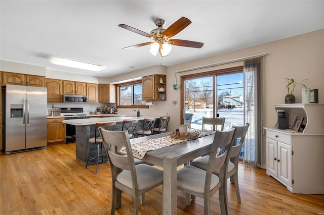 dining area with ceiling fan and light hardwood / wood-style floors