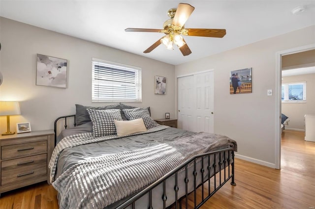 bedroom featuring ceiling fan, light wood-type flooring, and a closet