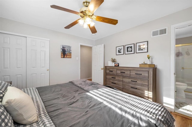 bedroom with connected bathroom, a closet, ceiling fan, and wood-type flooring