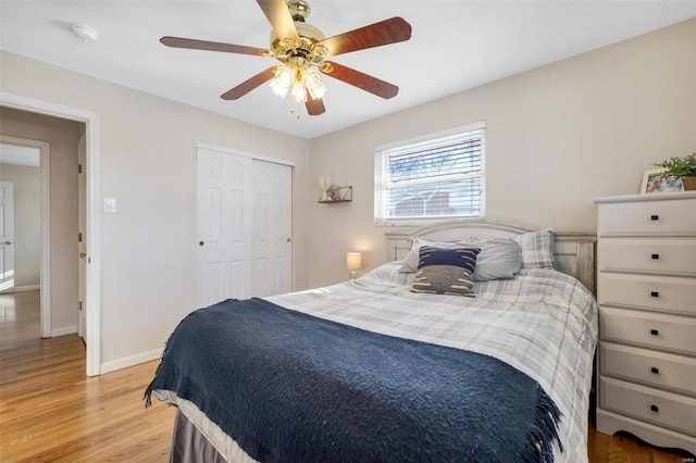 bedroom with ceiling fan, light hardwood / wood-style flooring, and a closet