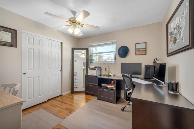 home office with light hardwood / wood-style floors and ceiling fan