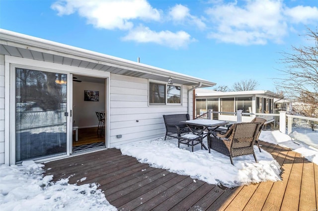 snow covered deck featuring a sunroom