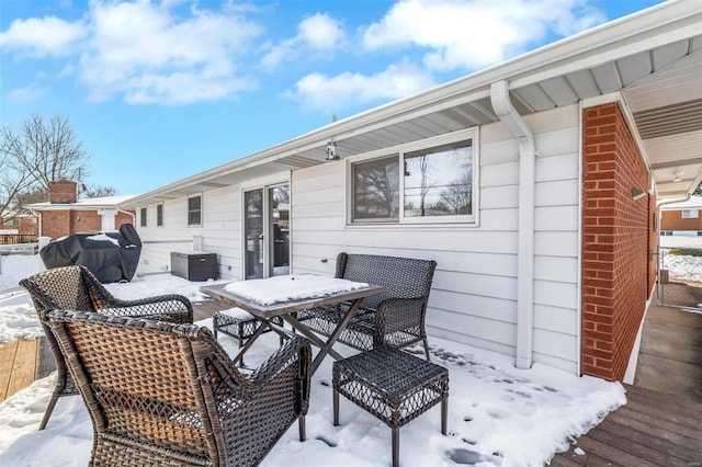 snow covered deck with a grill