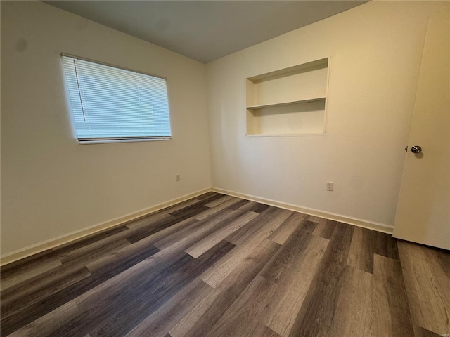 unfurnished room with dark hardwood / wood-style flooring