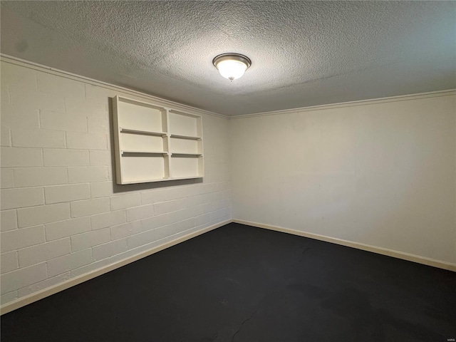 spare room featuring built in shelves and a textured ceiling