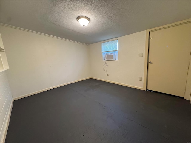 unfurnished room with cooling unit and a textured ceiling