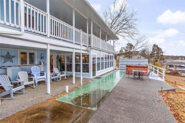 view of patio / terrace with a balcony and a hot tub