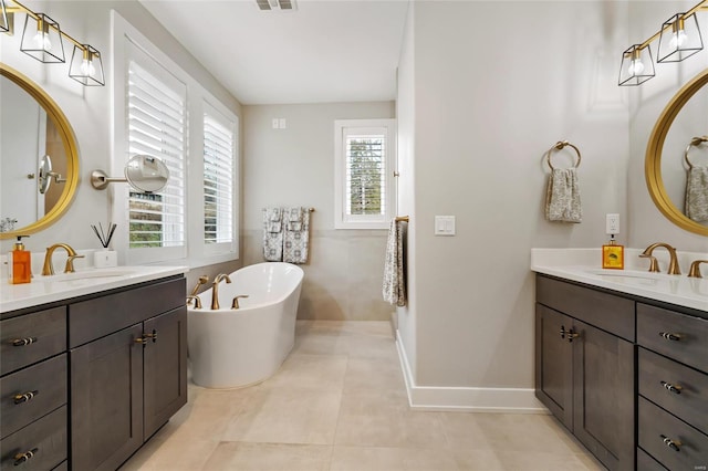 bathroom with tile patterned floors, a bathtub, and vanity