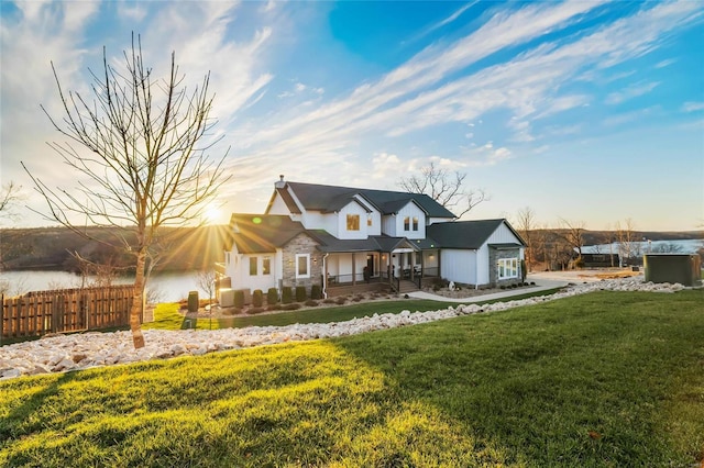 view of front of house with a front yard and a water view