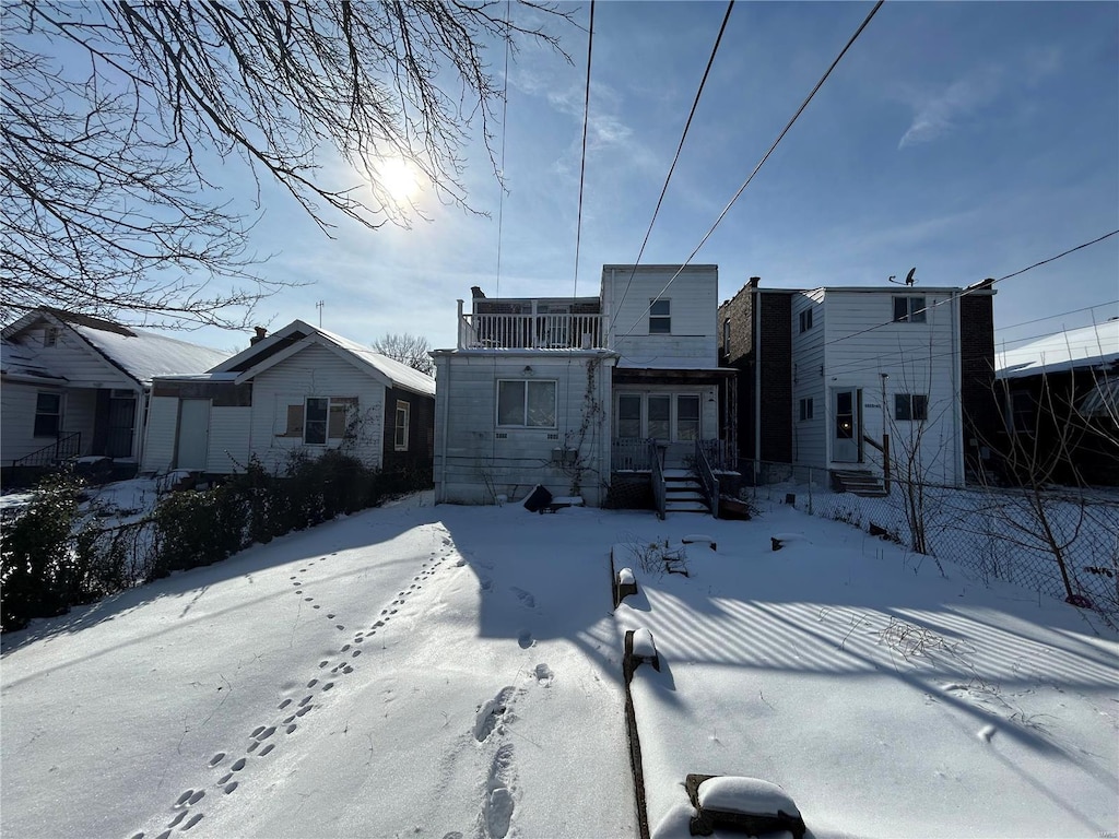 view of snow covered back of property