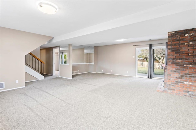 unfurnished living room featuring carpet and a wealth of natural light