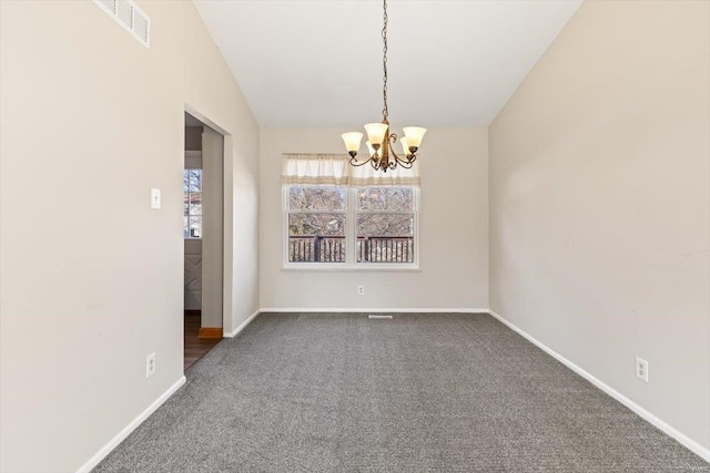 carpeted empty room featuring a notable chandelier